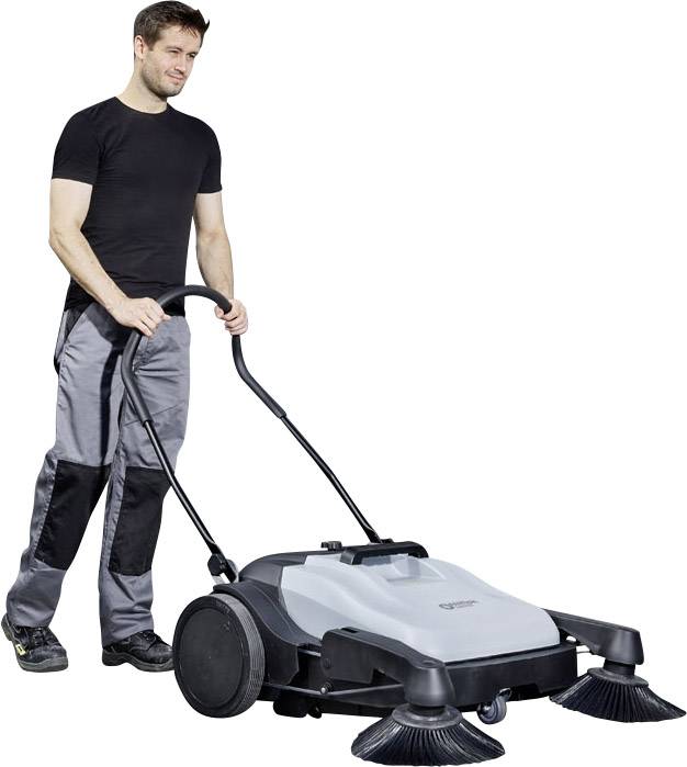 Muž v pracovnom oblečení tlačí veľkú zametaciu stroj po podlahe. Stroj má na prednej strane dve rotujúce kefy.