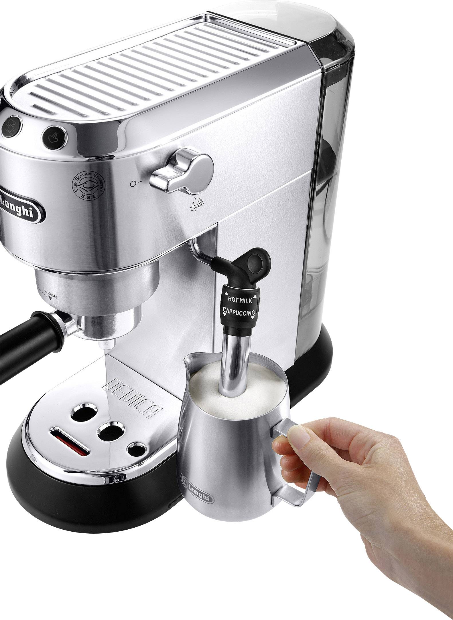 Strieborný espresso kávovar s rukou, ktorá obsluhuje džbán na mliečnu penu. Para vychádza z bočnej trysky.