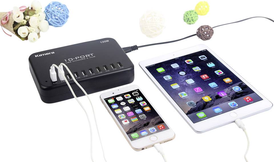 Nabíjačka s desiatimi USB portami nabíja smartfón a tablet. Obe zariadenia zobrazujú rôzne symboly aplikácií na svojich obrazovkách.