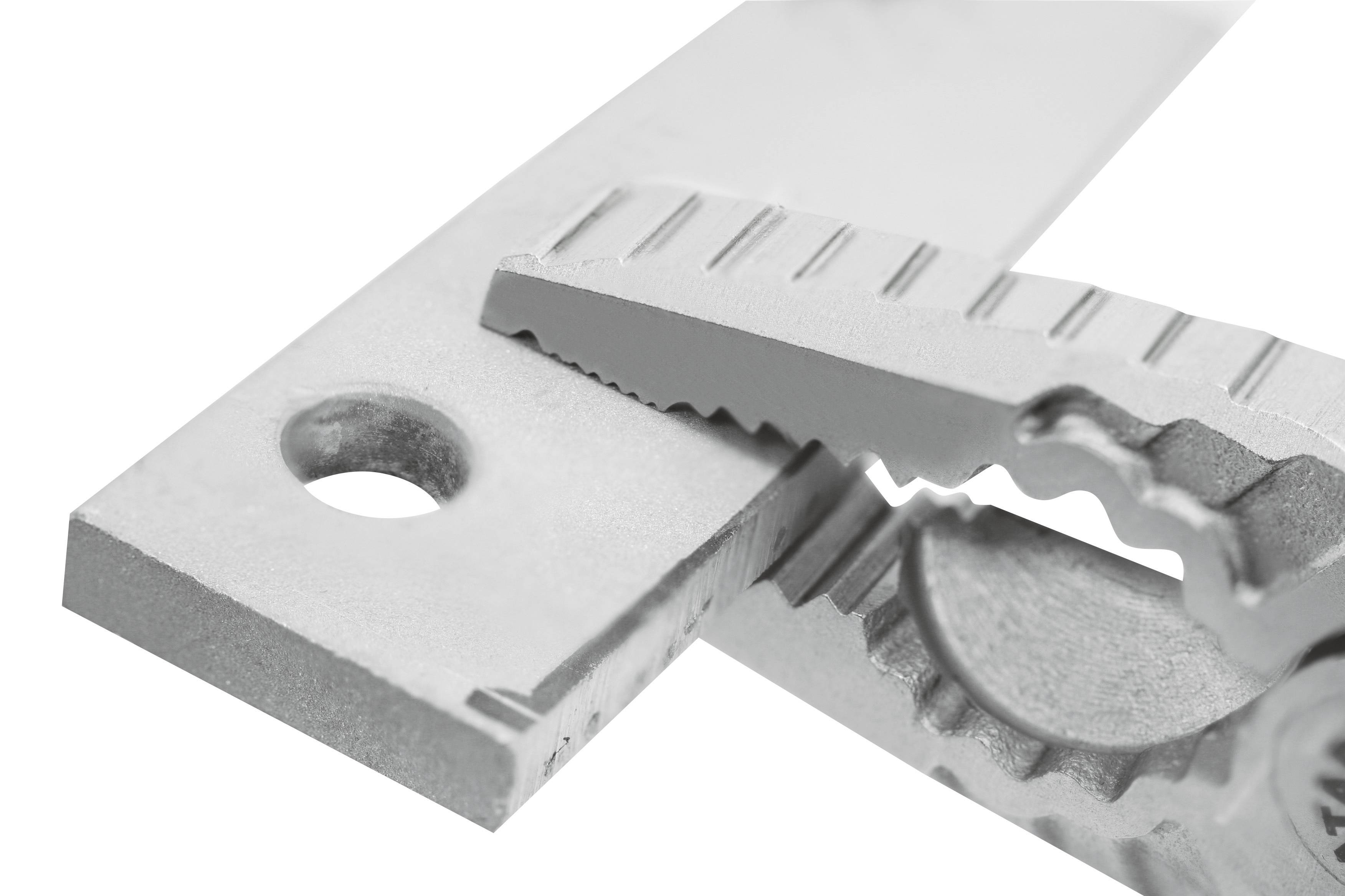 Kliešte pevne držia lesklý kovový kus s otvorom, ktorý naznačuje funkčný a technický kontext.