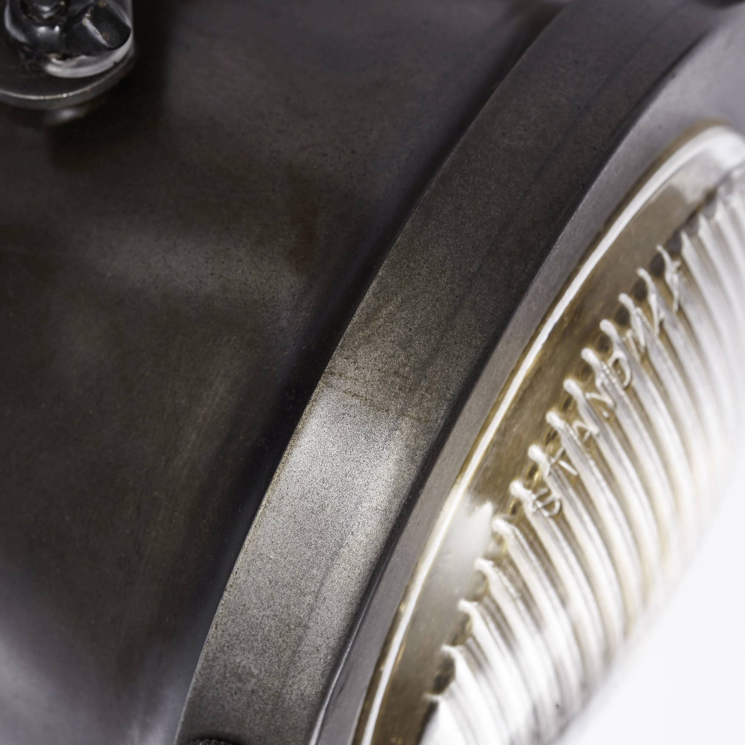 Detailný záber starého svetlometu s chrómovanými prvkami a skleným objektívom, ktorý vytvára retro atmosféru.