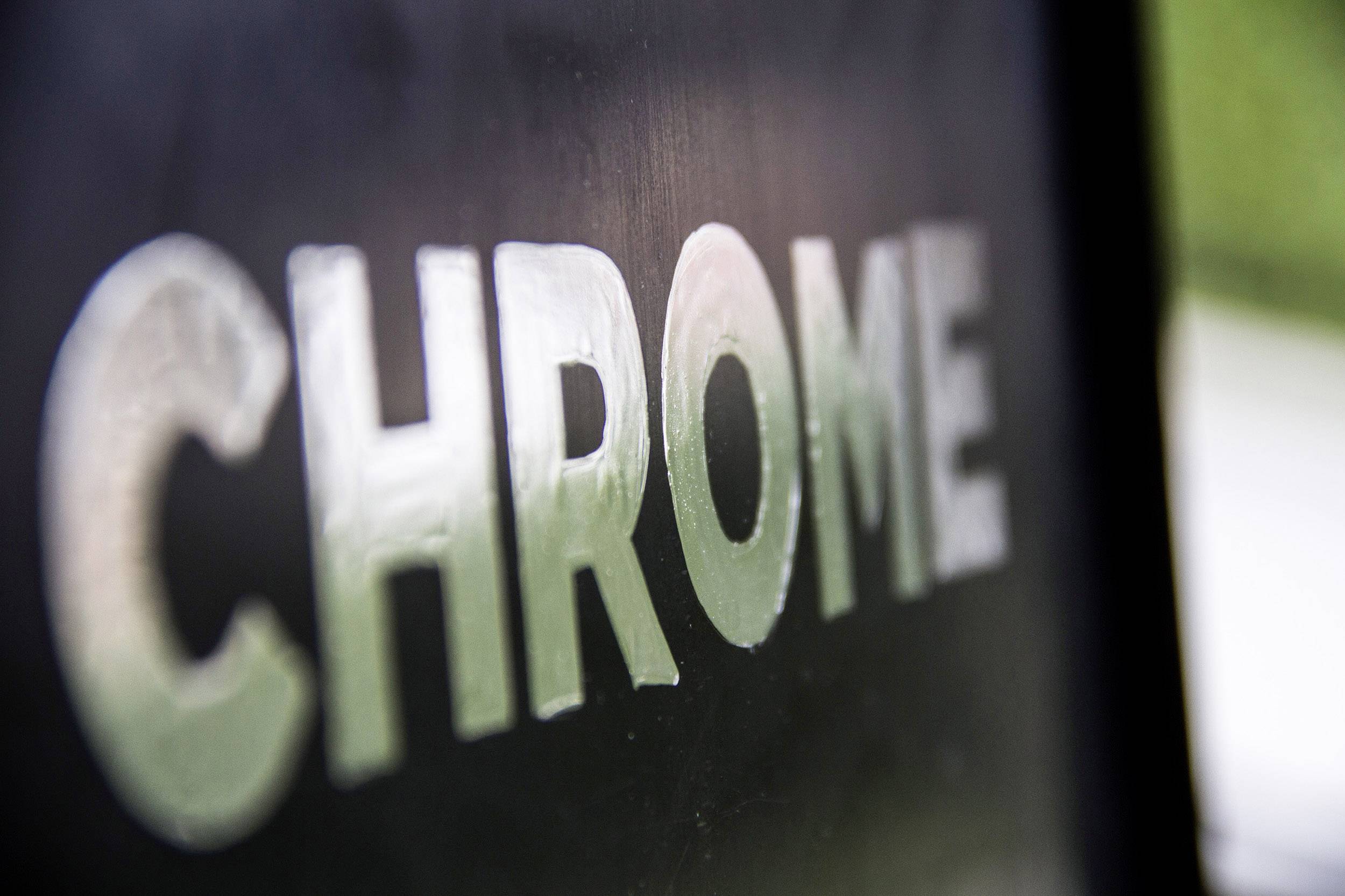 Nápis 'CHROME' je veľký a rozpoznateľný na tmavom povrchu.