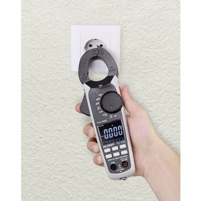 Jedna ruka drží digitálny multimeter vedľa elektrickej zásuvky, na displeji je zobrazená hodnota '0,000', pripravená na meranie napätia.