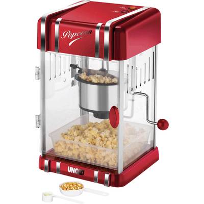 Červeno-biely stroj na popcorn s popcornom vnútri. Malá lyžica s nespukanou kukuricou vedľa neho.