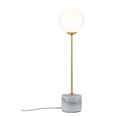 Stolová lampa s guľovitým bielym tienidlom na zlatej tyči a mramorovej podstave. Kábel je viditeľnou súčasťou dizajnu.