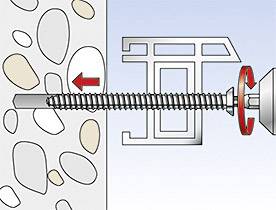 Ilustrácia skrutkovej kotvy, ktorá sa otáča do steny s okruhliakmi. Červený šípka ukazuje smer skrutkovania.