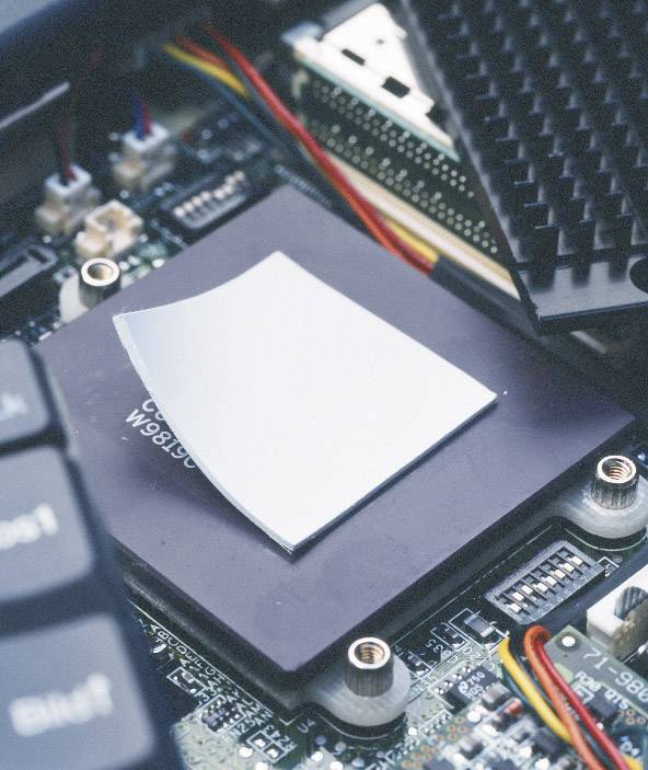 Detailný záber počítačovej dosky s procesorom a viditelnými elektronickými komponentmi a káblami.