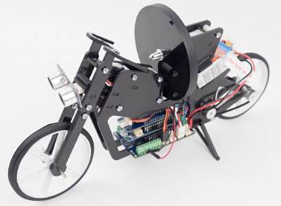 Model elektronickej motocyklovej platformy s viditelnými vodičmi a komponentmi, ktorý vyzerá ako rozpracovaný vývojový projekt.