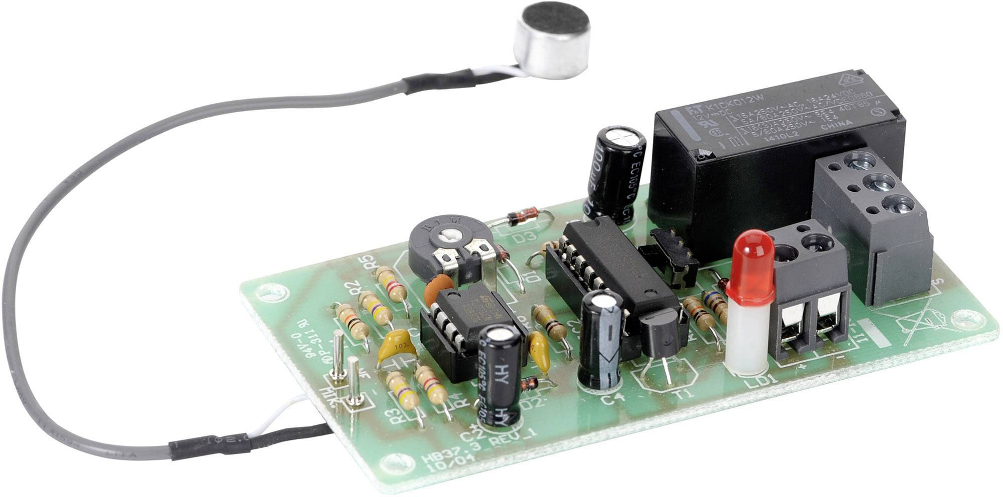 Elektronický obvod s rôznymi komponentmi vrátane mikrofónu, odporov, relé a kondenzátorov, namontovaný na doske plošných spojov.