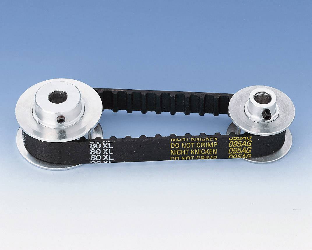 Dve strieborné ozubené kolesá prepojené čiernym ozubeným remienkom na modrom pozadí. Na remienku je napísané 'DO NOT CRIMP'.