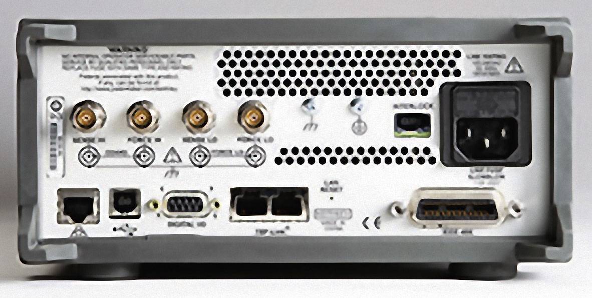 Zadná strana elektronického zariadenia s viacerými prípojkami a rozhraniami vrátane napájacieho konektora a BNC konektorov.