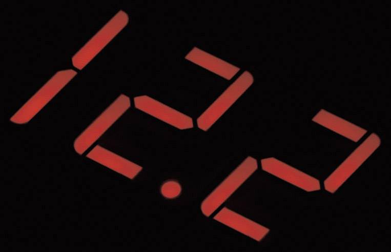 Červený LED displej zobrazuje čas '15:32'. Tmavé pozadie zvýrazňuje číslice.