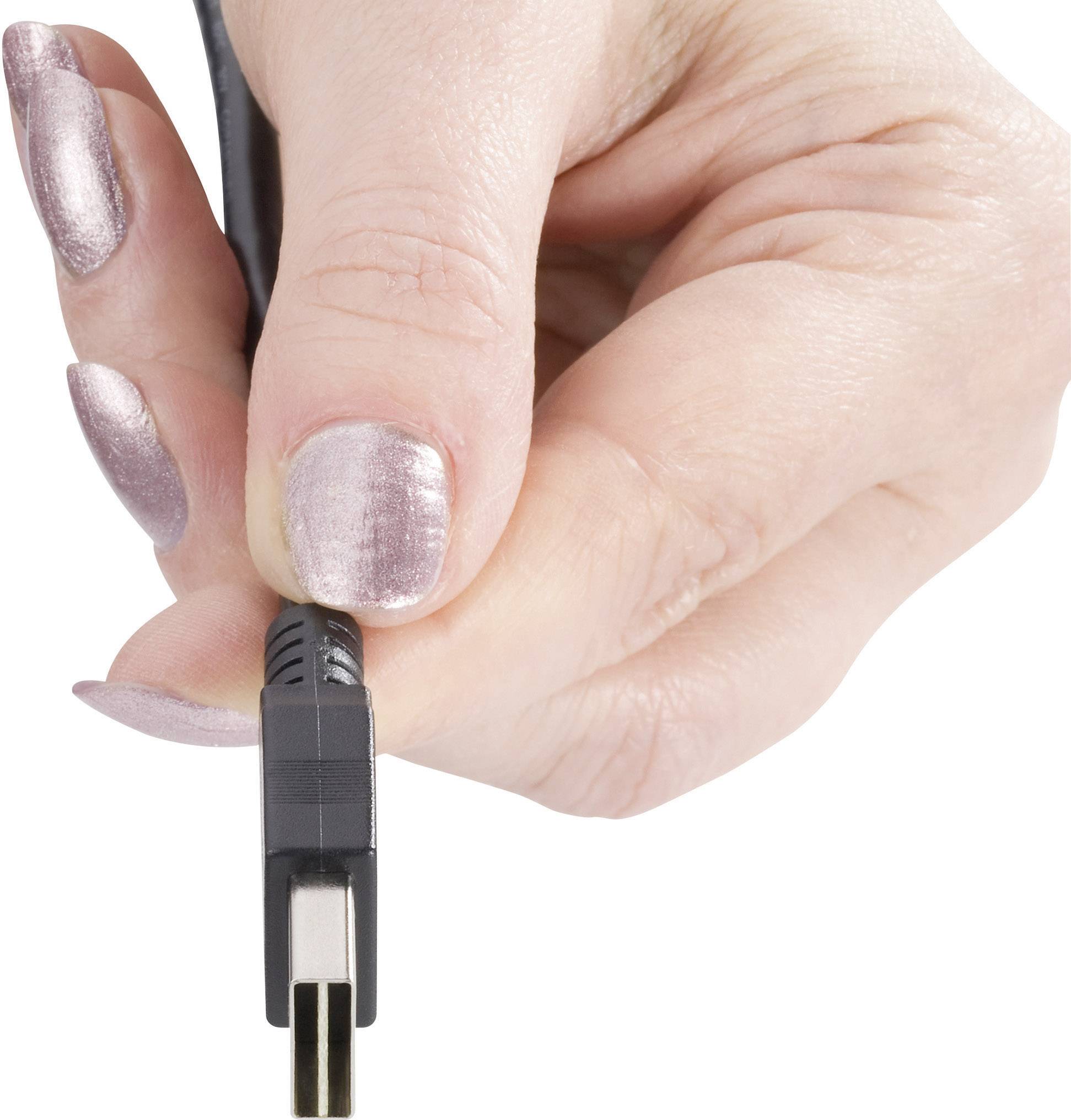 Jedna ruka drží čierny USB konektor.