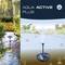 'Aqua Active Plus' Fiap-logotip, prikazuje ribniško krajino s škropilnikom v vodi, rastlinami in cvetlicami v ozadju.