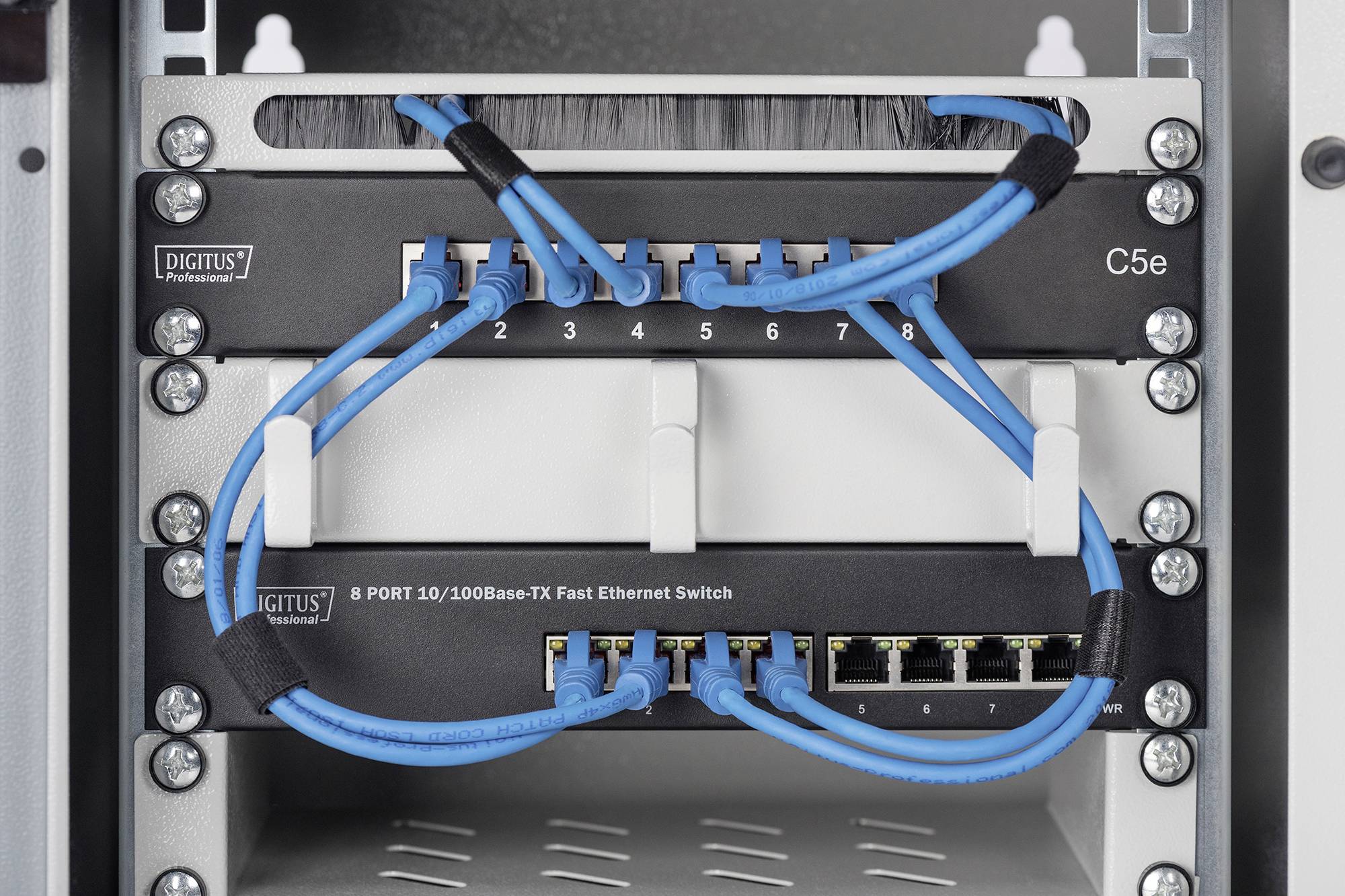 Ethernet stikalo, povezano z več modrimimi omrežnimi kabli, podpira 10/100Base-TX Fast Ethernet.