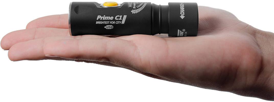 Roka drži majhno črno svetilko z napisom 'Prime C1'.