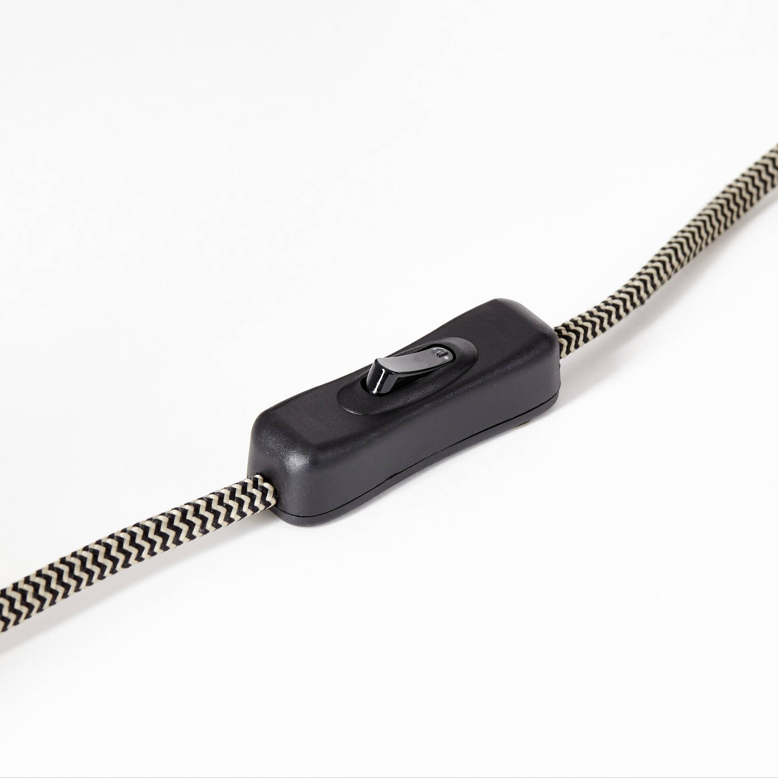 Črno-belo vzorčast kabel s črnim preklopnim stikalom na sredini na beli podlagi.