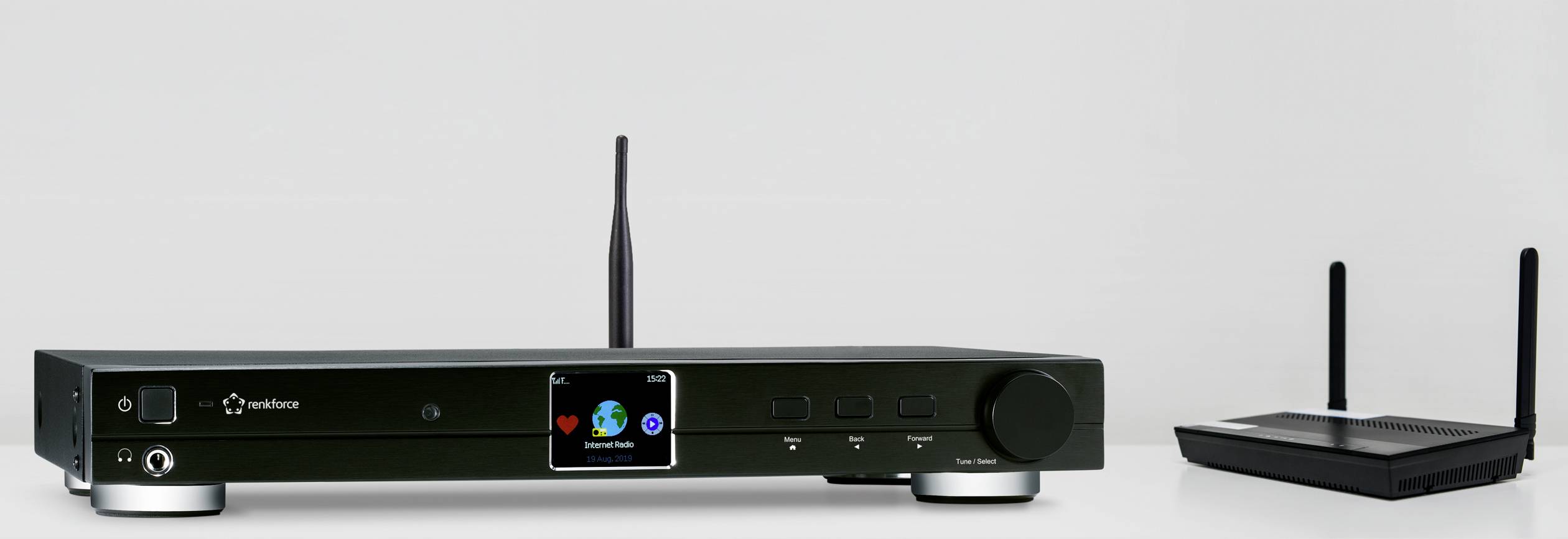 Črn stereo sprejemnik z anteno na levi in majhen usmerjevalnik WLAN z dvema antenama na desni strani na belem ozadju.