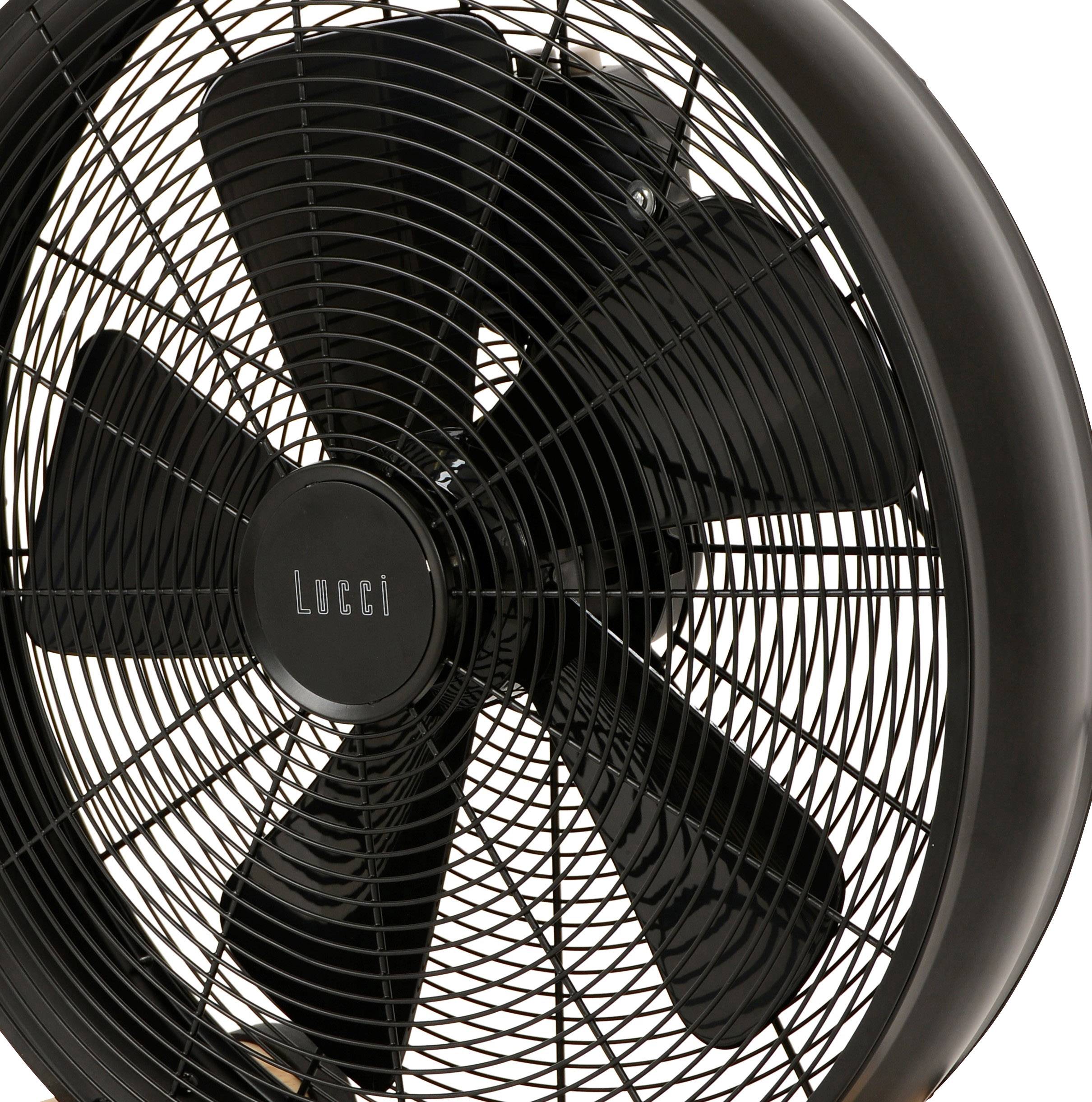 Črn ventilator s petimi rotorskimi krili stoji čelno pred belo podlago. Levo je natisnjen naziv blagovne znamke.