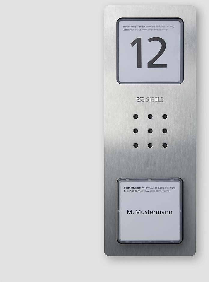 Kovinska tablica s številko 12 zgoraj in imenom 'M. Mustermann' spodaj; vmes mikrofonske odprtine; sistemom za zvonenje.