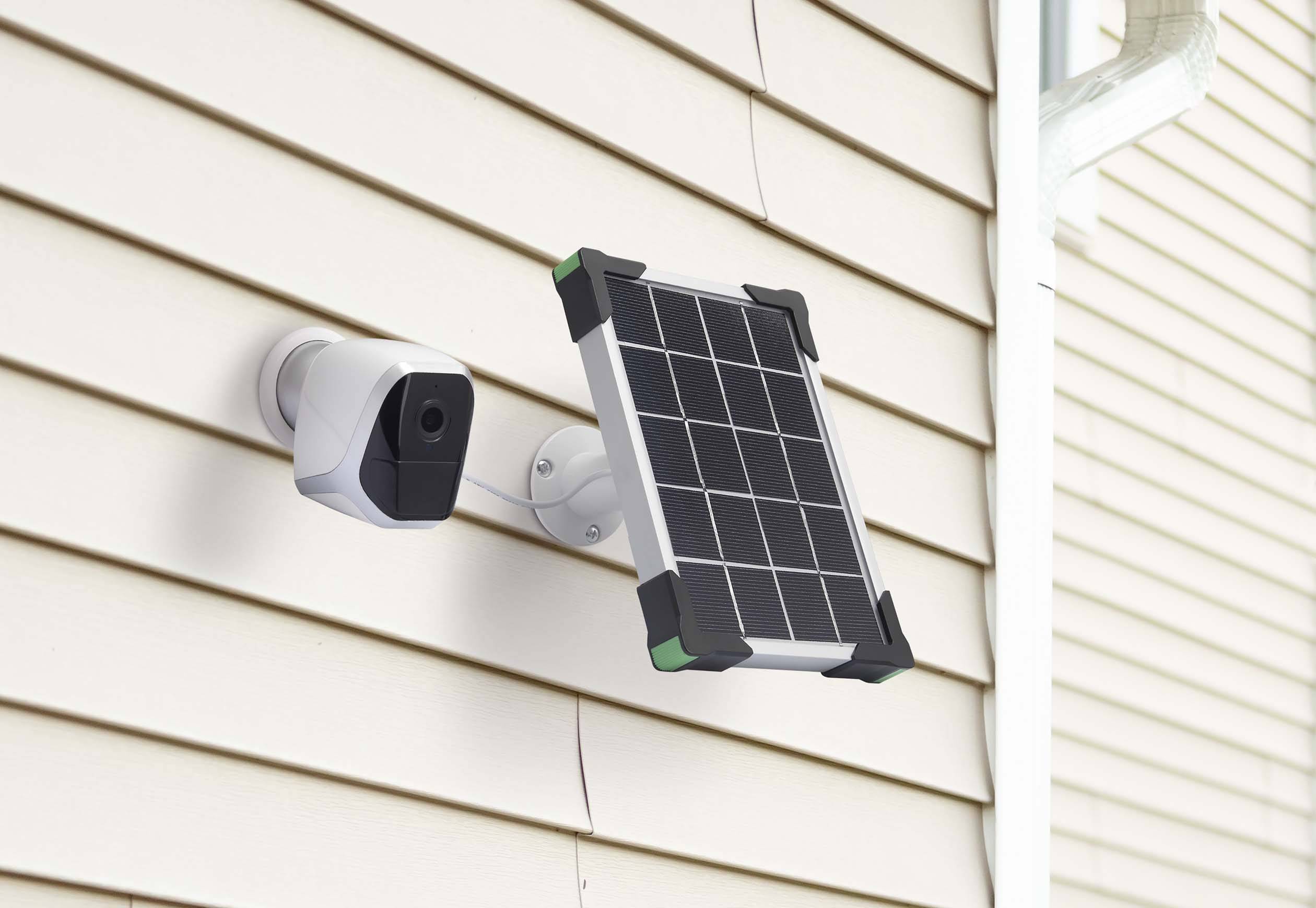 Nadzorna kamera in solarni panel, nameščena na zunanji steni hiše, za uporabo sončne energije za kamero.