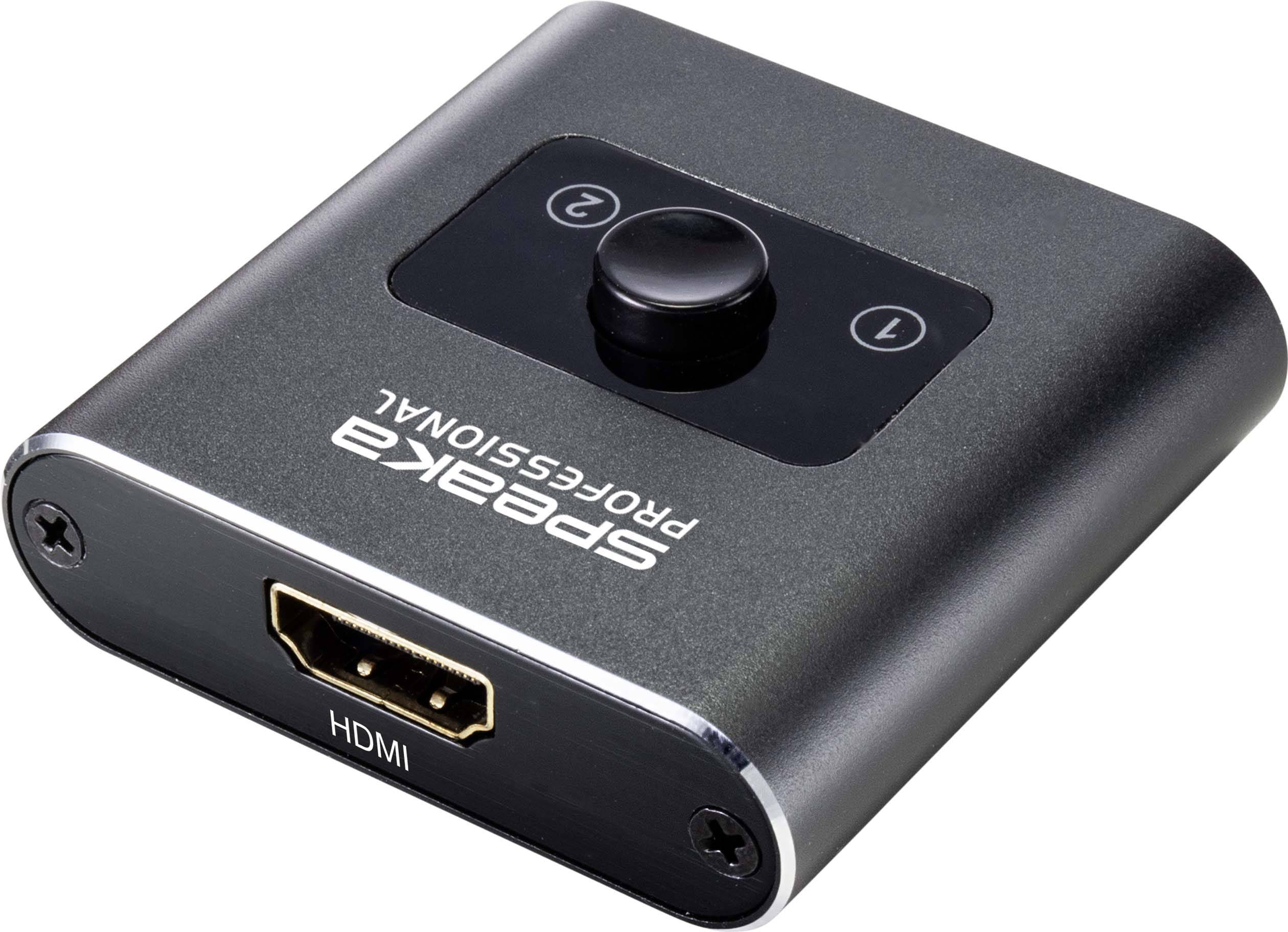 Črn HDMI stikalo z osrednjim gumbom in dvema priključkoma, označenima z "1" in "2". Napis: "SPEAKA PROFESSIONAL".
