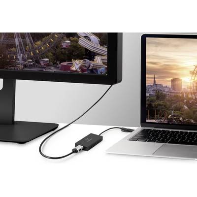 Prenosni računalnik je povezan z monitorjem. Vmes je priključen adapter. Monitor prikazuje sliko velikega kolesa na gugalnici ob sončnem zahodu.