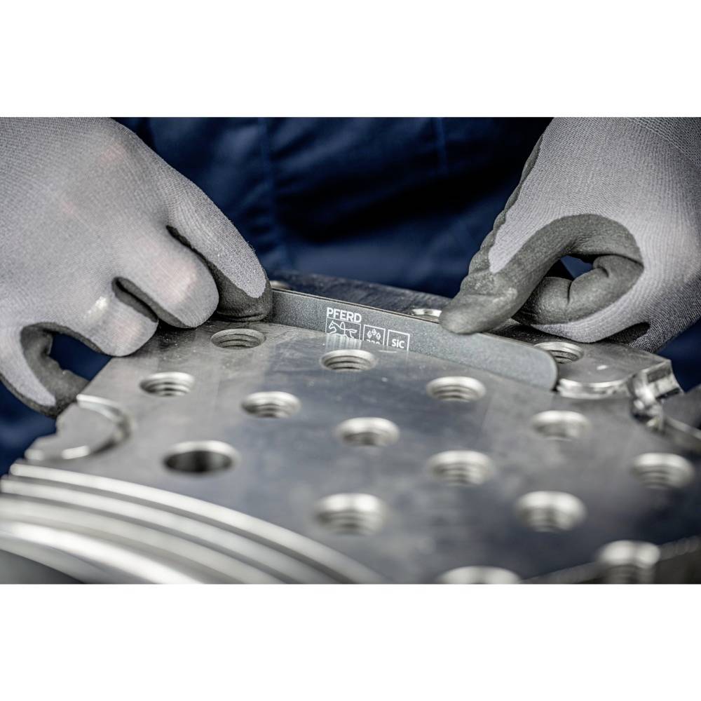 Oseba z sivimi rokavicami datira kovino na strojnem obdelovancu. Pila je označena z 'PFERD'.