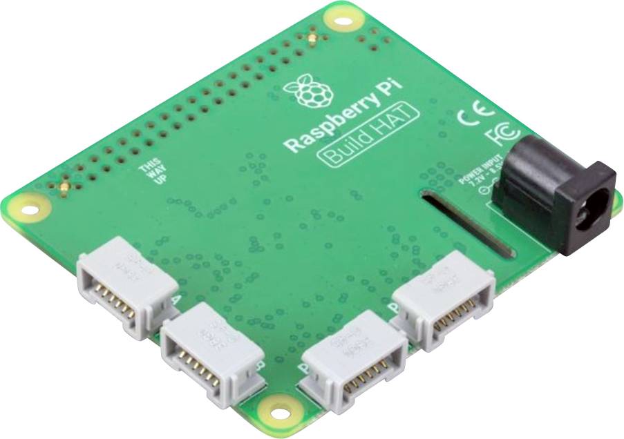Raspberry Pi Build HAT na zelenem mikrokrmilniškem vezju, z več priključki in črnim napajalnikom na desni strani.
