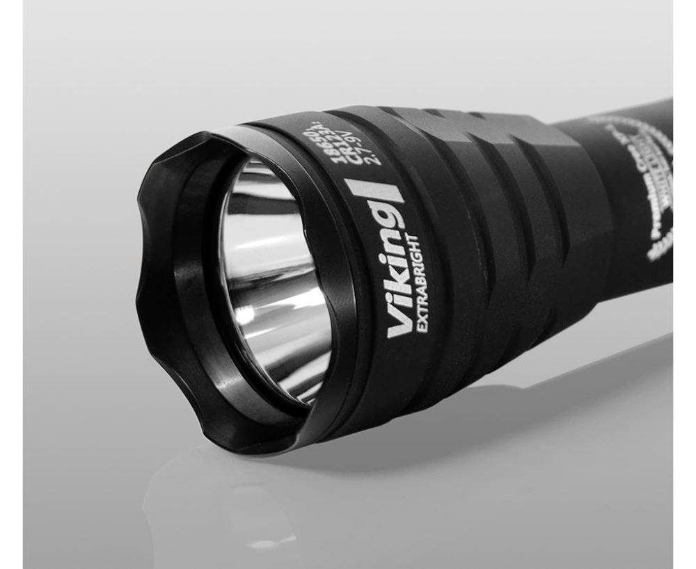 Črna svetilka leži na gladki površini, z napisom 'Viking Extra Bright' na ročaju.