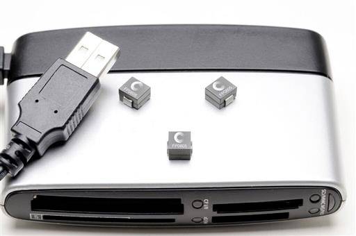 Zunanja trda disk z USB priključkom in tremi majhnimi, kvadratnimi elektronskimi komponentami na njej.