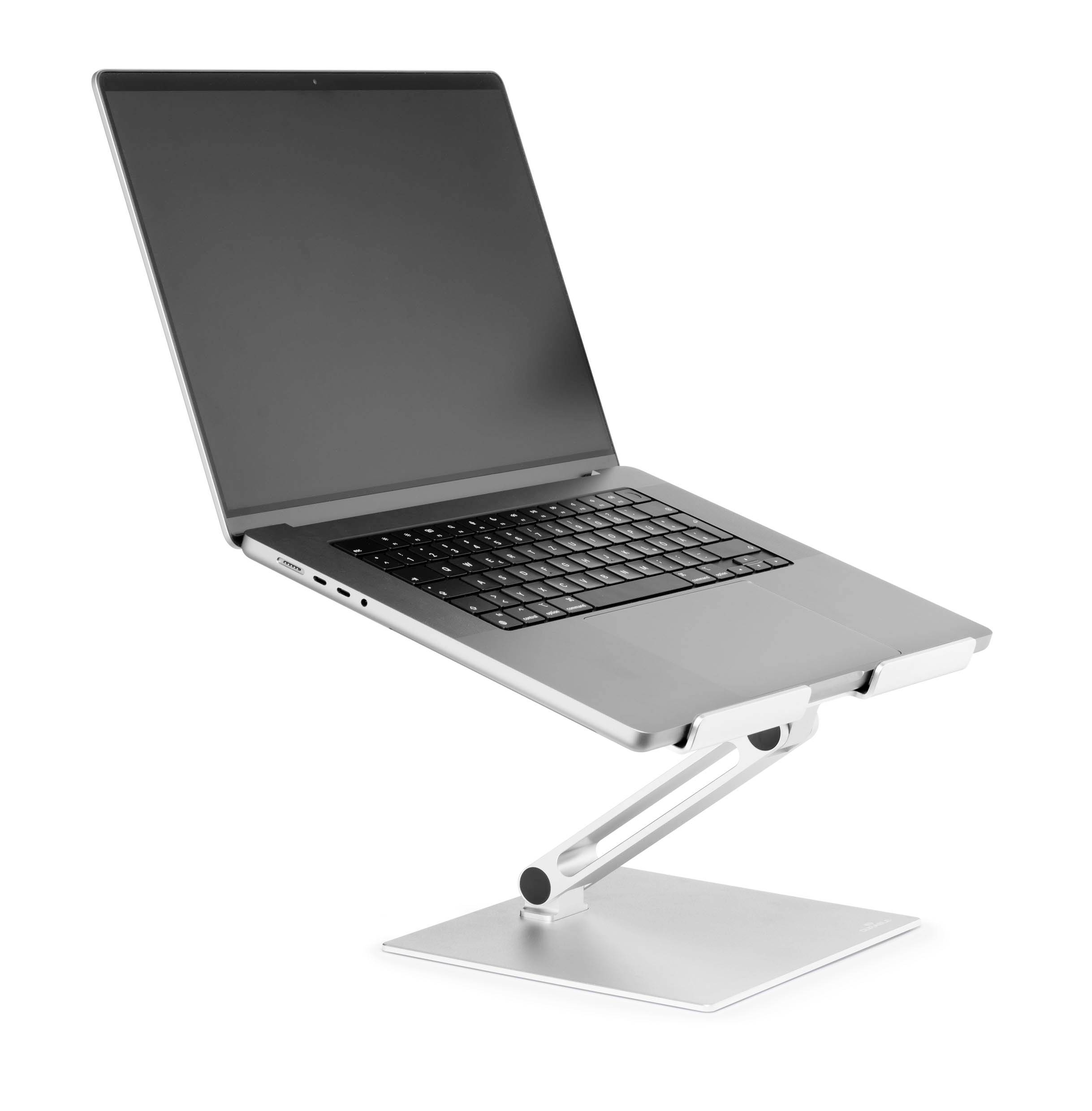 Prenosni računalnik na srebrnem, nastavljiv stojalu, nagnjen navzgor za ergonomsko izboljšanje uporabe prenosnika.