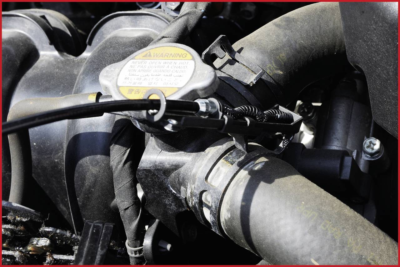 Motor s cevmi in kabli. Zgoraj je na pokrovu mogoče opaziti opozorilni znak.