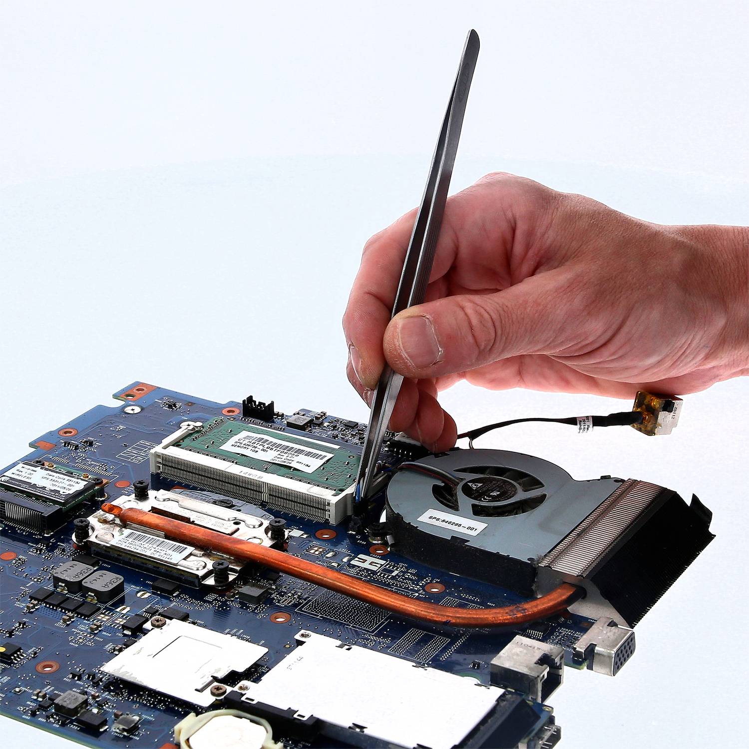 Roka drži izvijač in dela na računalniški matični plošči, obdani z različnimi elektronskimi komponentami.