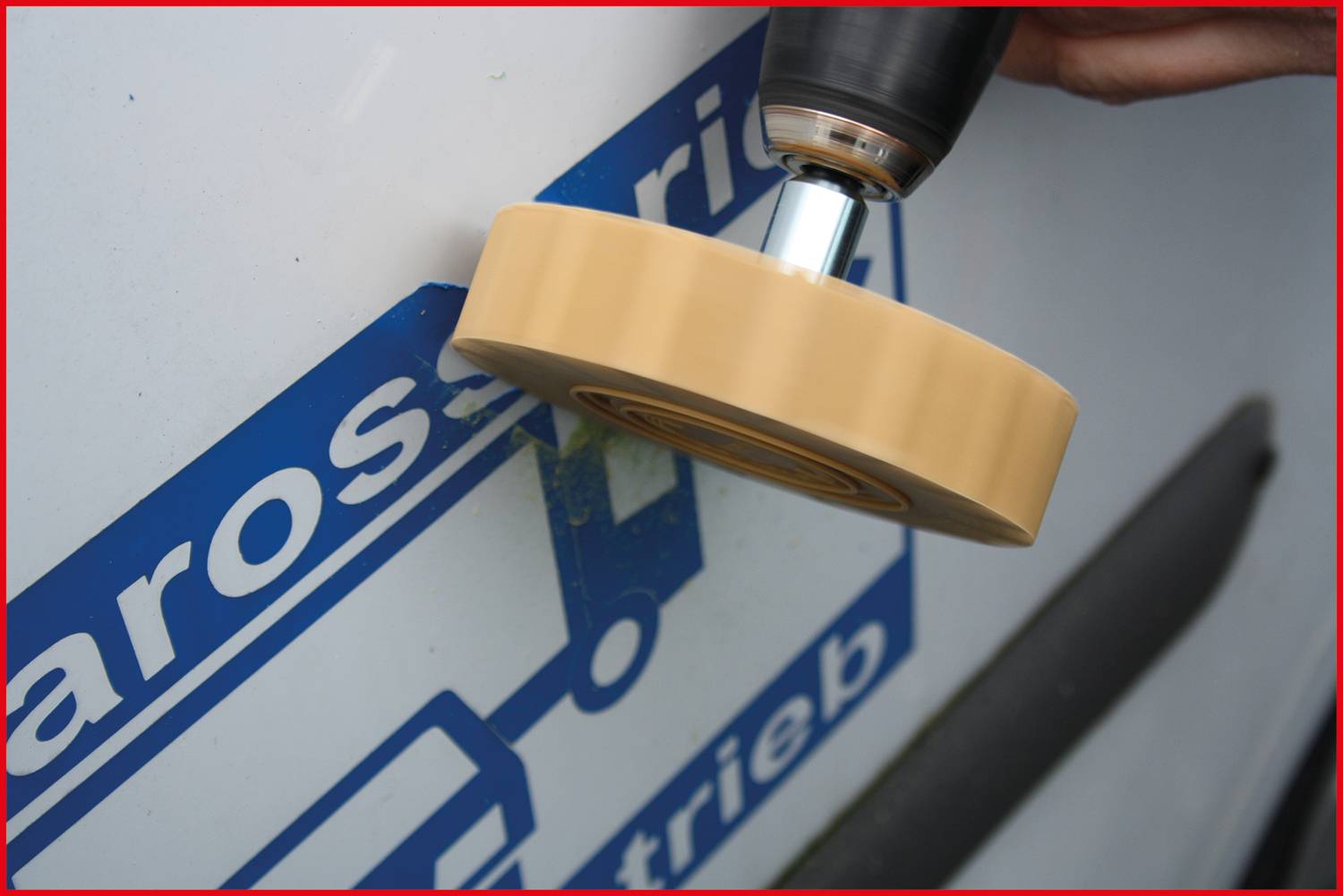 Električno orodje odstranjuje nalepko z vozila.