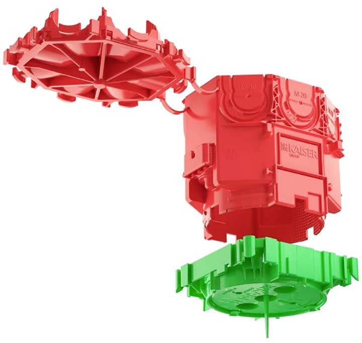 Dva plastična dela, rdeč in zelen, ki se prilegata drug drugemu. En del kvadratne oblike in en okrogel, ploščat del.
