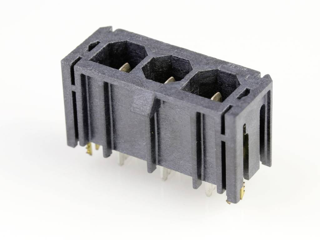 Črn plastičen connector s tremi priključki in vidnimi kovinskimi kontakti, na beli podlagi.