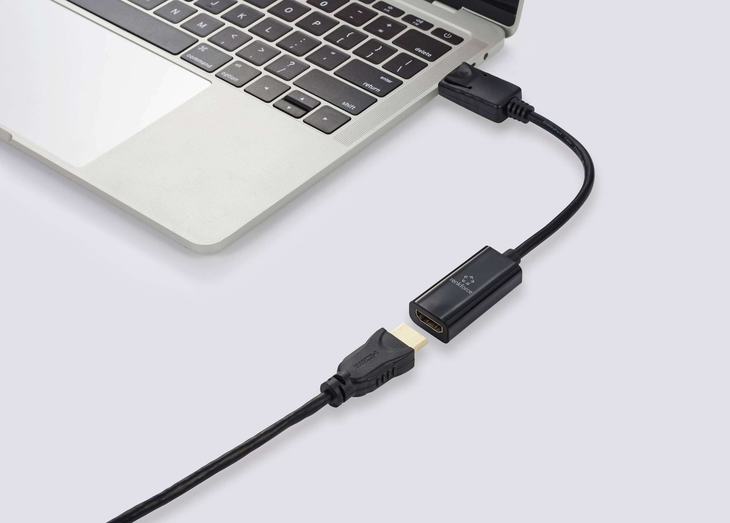 Prenosni računalnik, povezan s kablom HDMI, ki je priključen na adapter. Adapter povezuje kabel z prenosnim računalnikom.