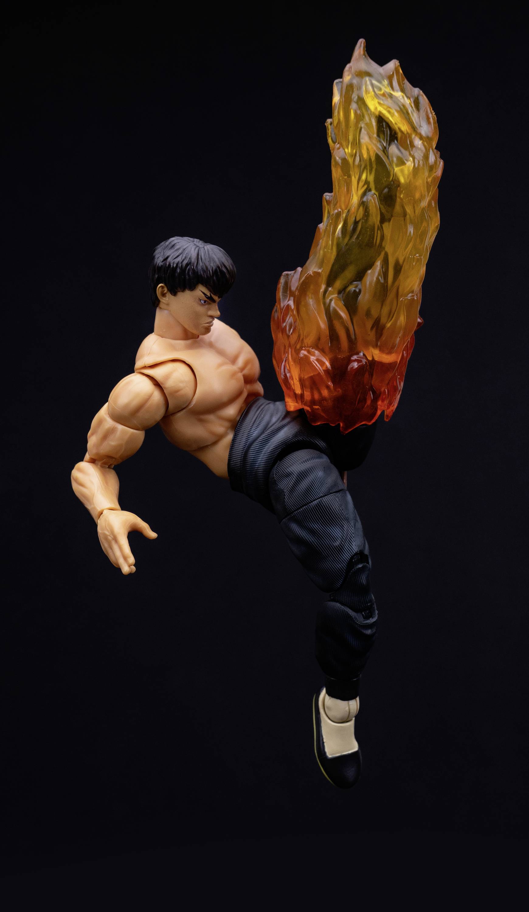 Igrača figura bojevalne umetnosti v skoku z gorečo nogo.