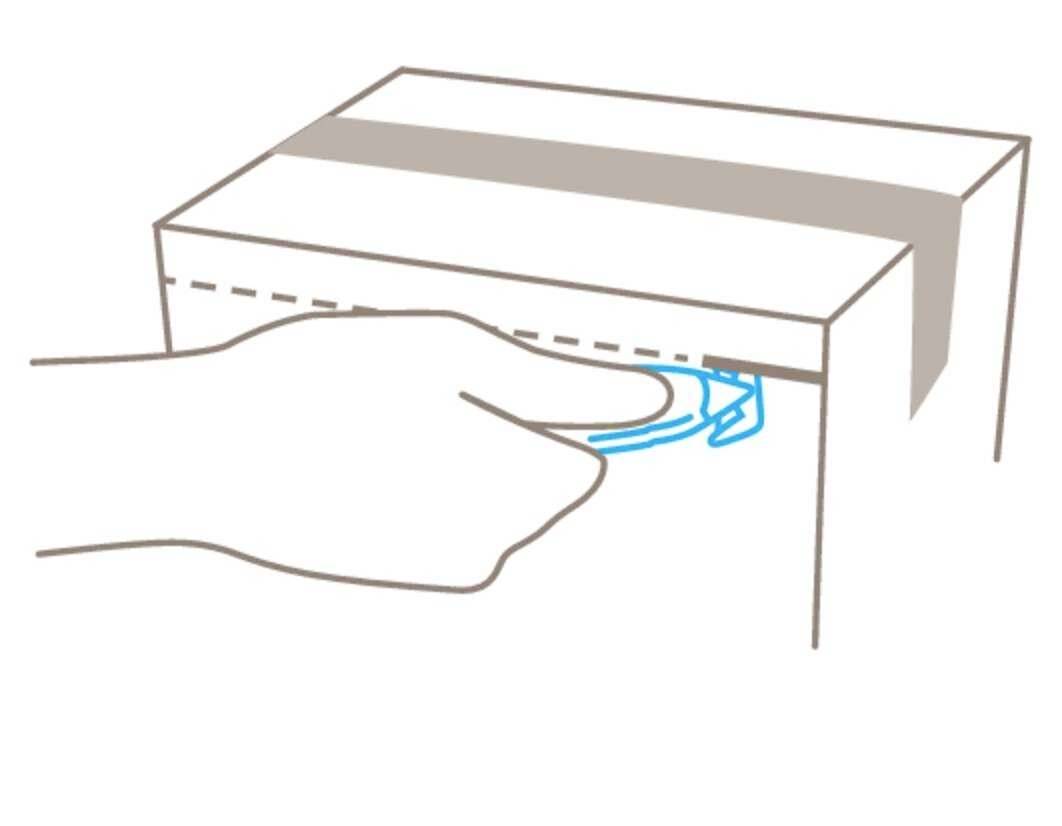 Roka potegne moder transportni trak iz kartona.