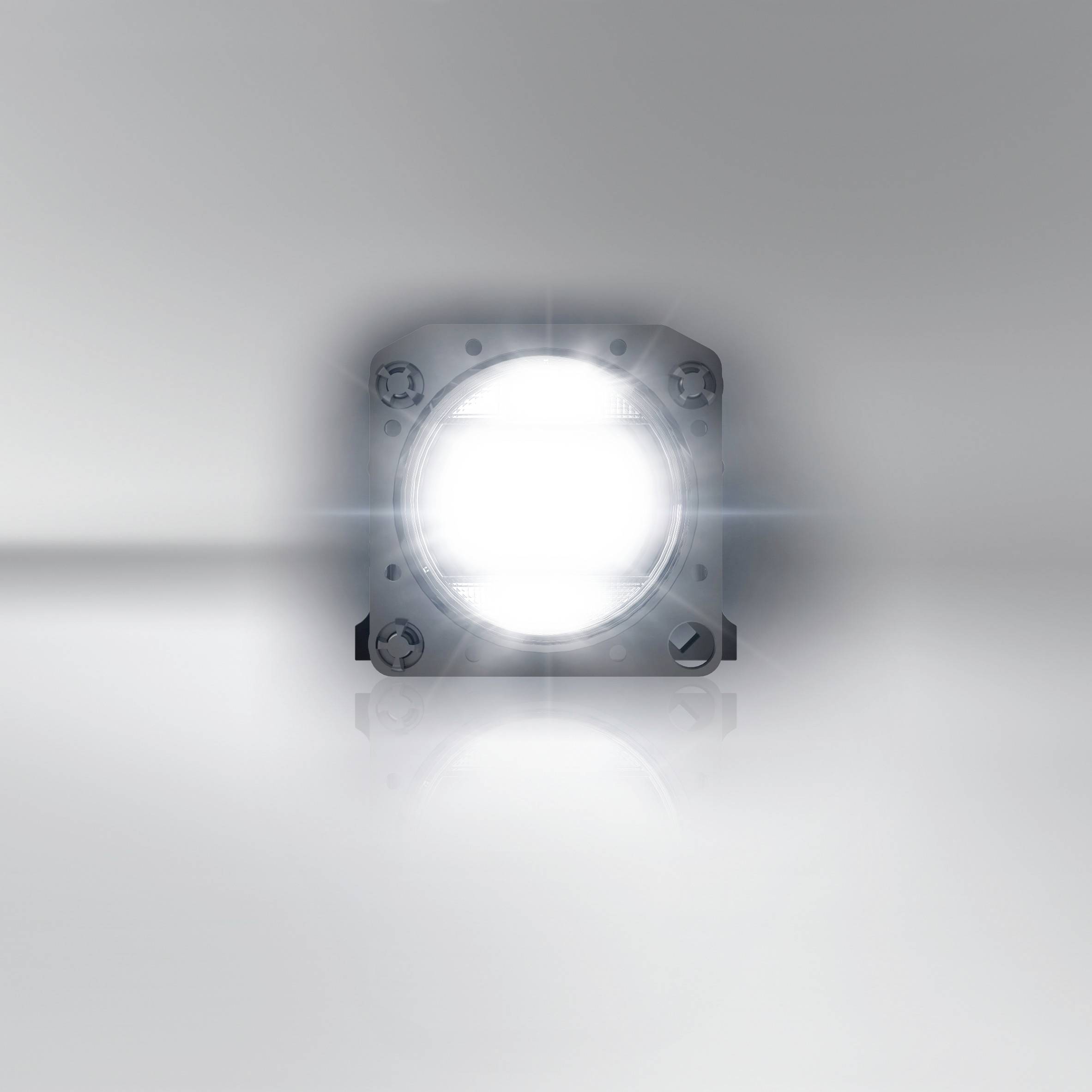 Svetla LED-luč na reflektivni površini. Seva intenzivno svetlobo, ki ima oslepljujoč učinek.