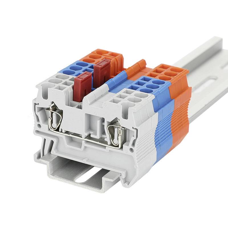 Električni vtični priključek z večbarvnimi sponkami, nameščen na vodilno letev, pripravljen za uporabo v elektronskih inštalacijah.