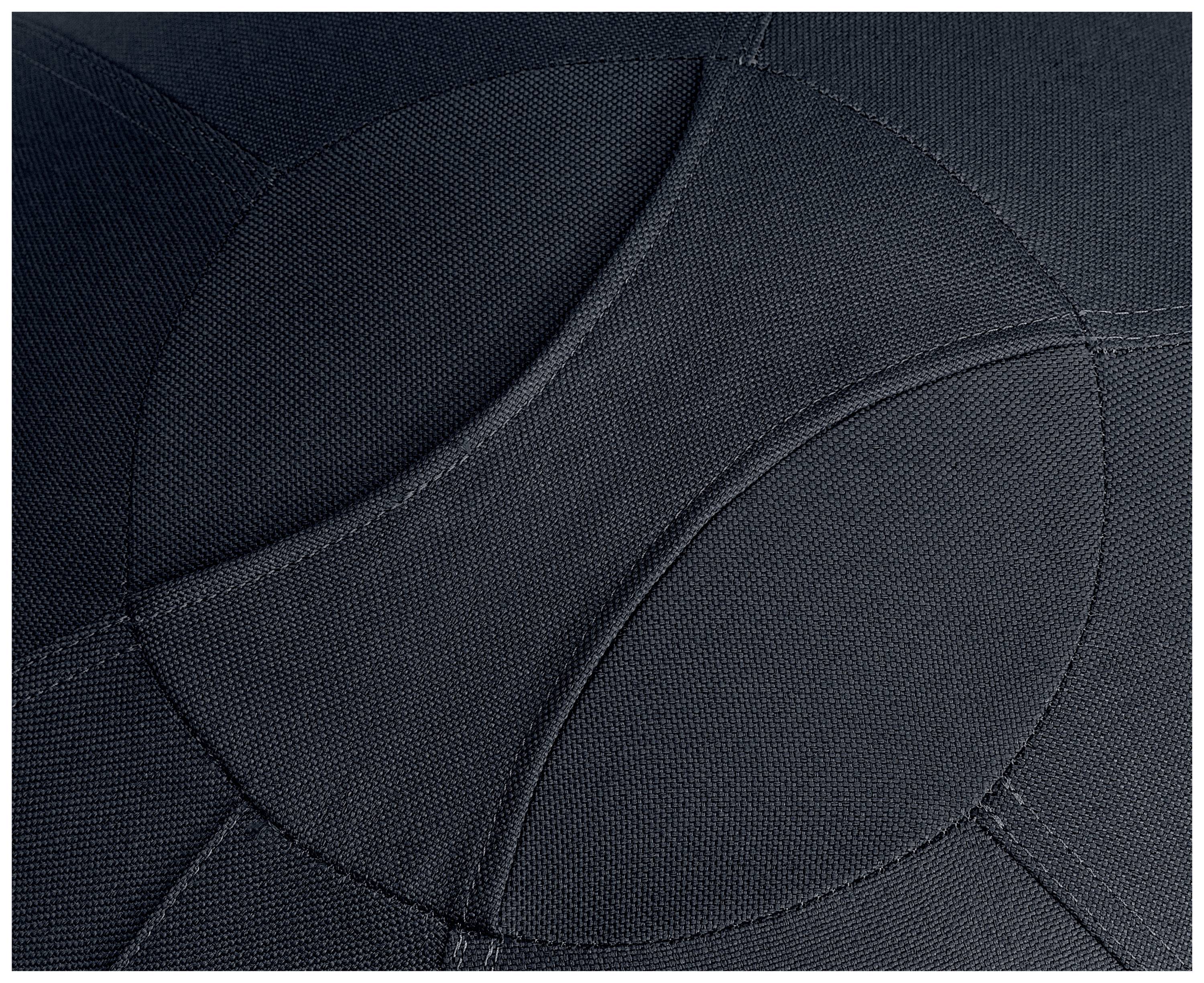 Bližnji posnetek temne tekstilne površine z prekrivajočimi se krogi in šivi.