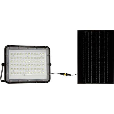 Pravokoten LED reflektor z numerous svetlobnimi diodami je preko kabla povezan s solarnim panelom, ki stoji poleg njega.