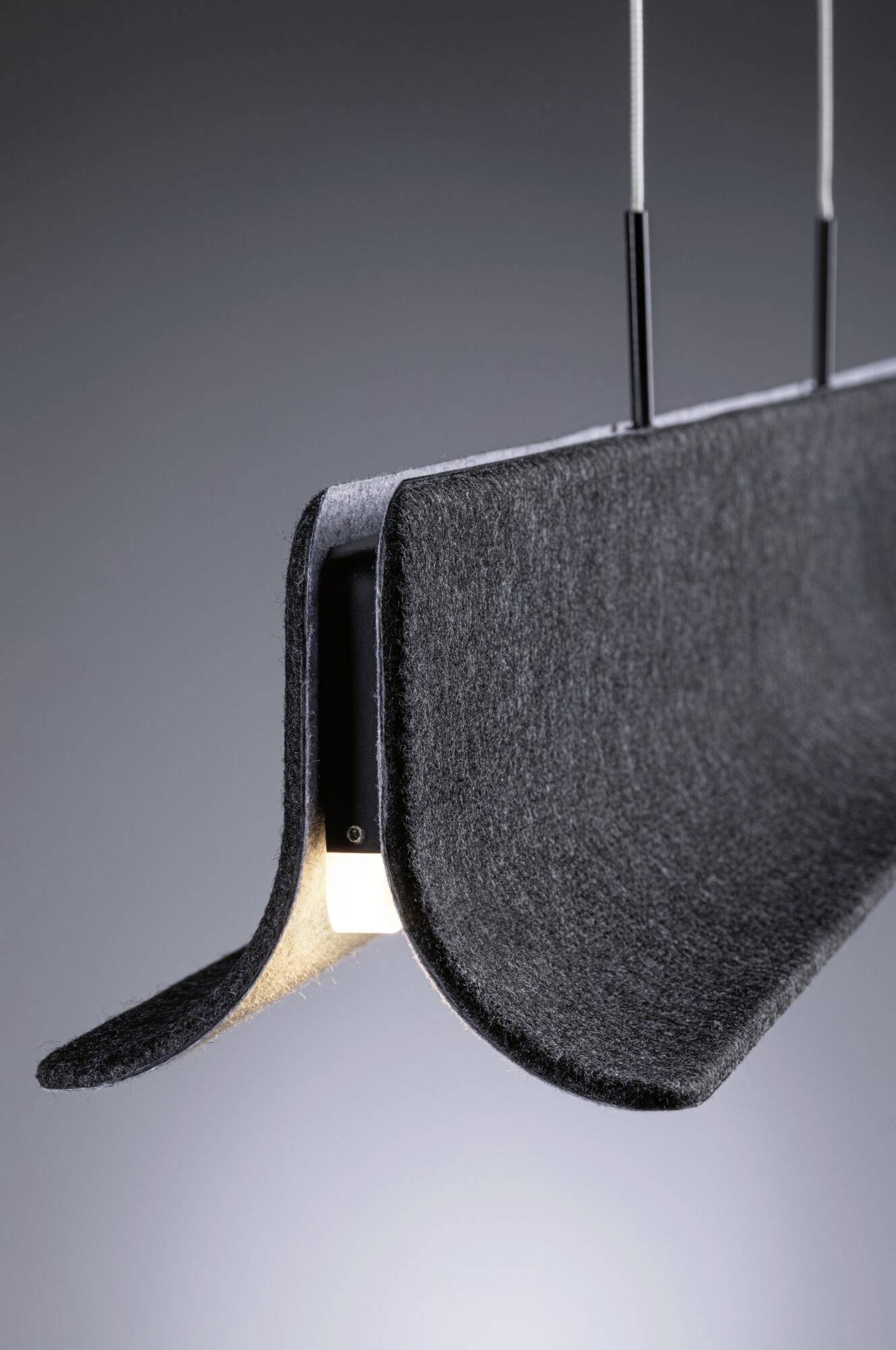 Viseča svetilka modernega dizajna: Oblikovana črna snov, ki obdaja svetilo. Elegantna, minimalistična estetika.