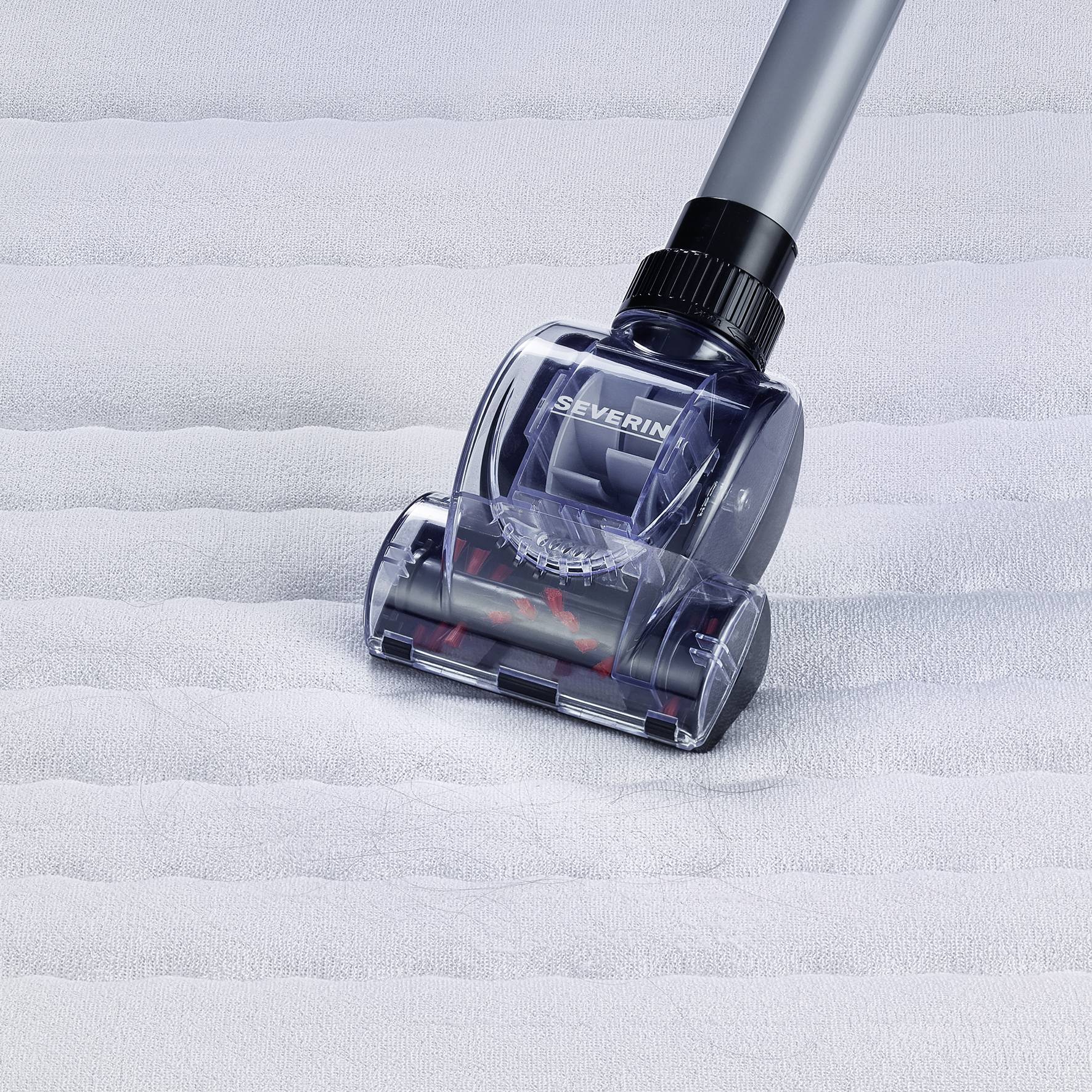 Sesalčeva glava sesa čez belo, strukturirano površino. Je prozorna in prikazuje vrteče se krtačo.