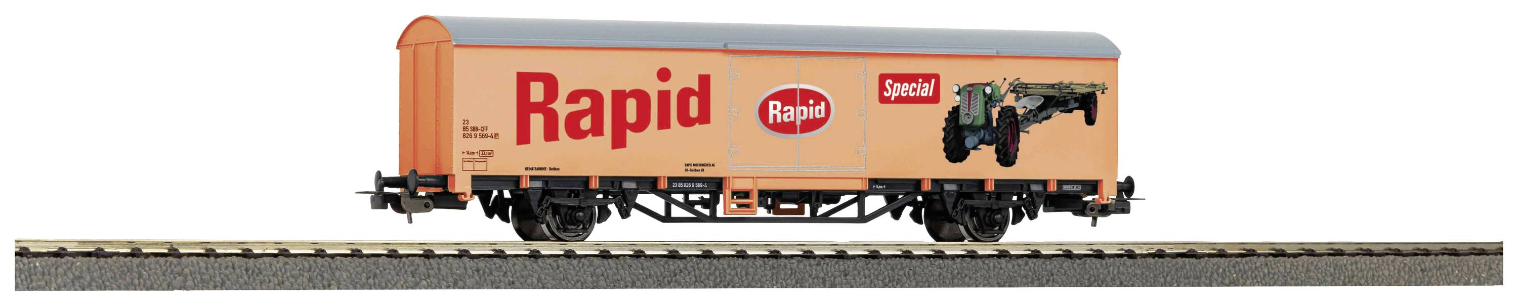 Oranžen tovorni vagon z napisom 'Rapid'. Vagon vozi po železniških tirih.