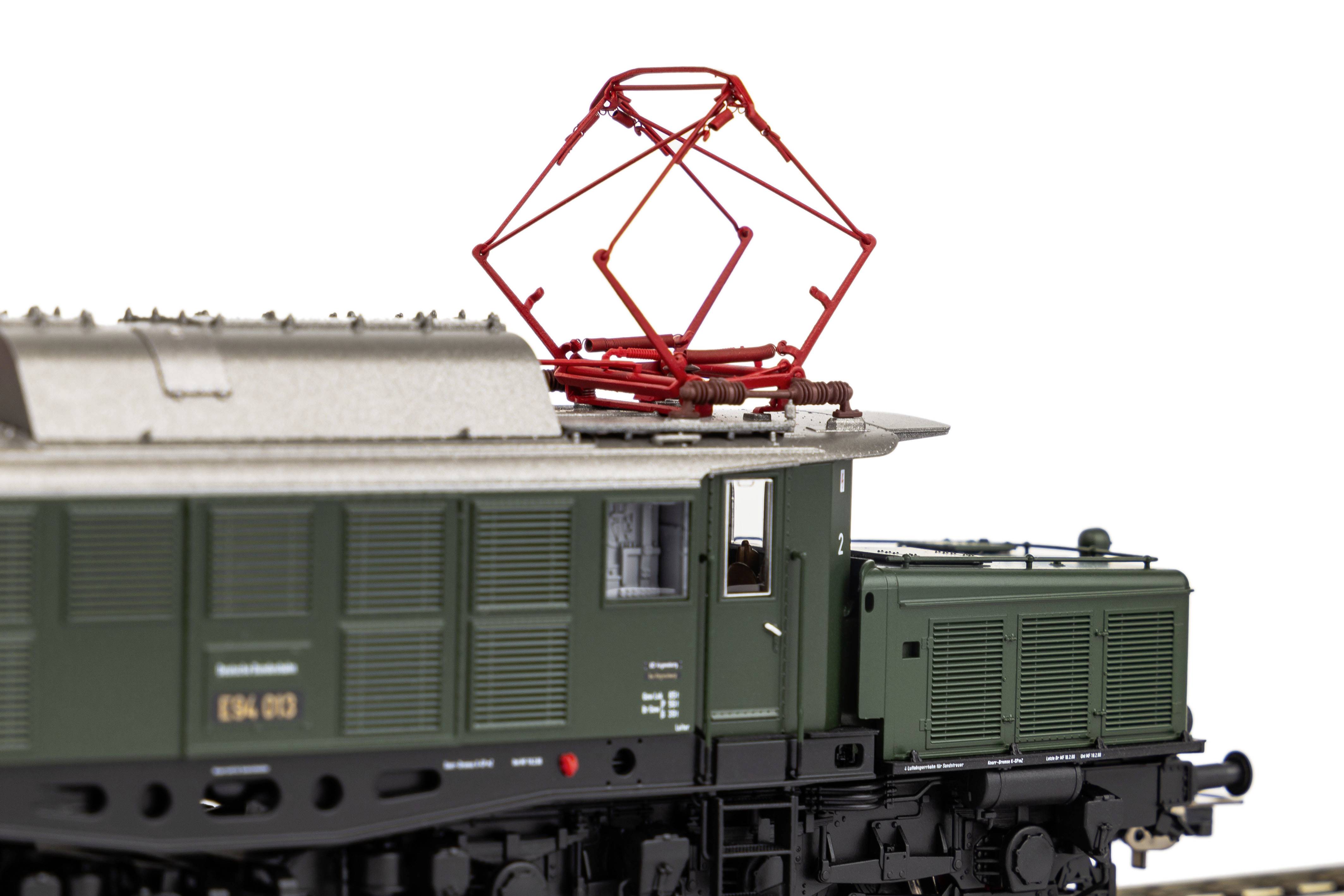 Podroben model zgodovinske zelene električne lokomotive z zbiralnikom toka na strehi, osredotočen na pogled od zgoraj.