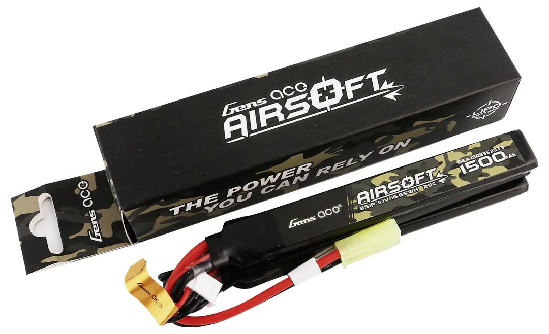 Pravokoten akumulator z napisom 'Gens Ace Airsoft', kapacitete 1500mAh, leži poleg črno-zelene embalaže.