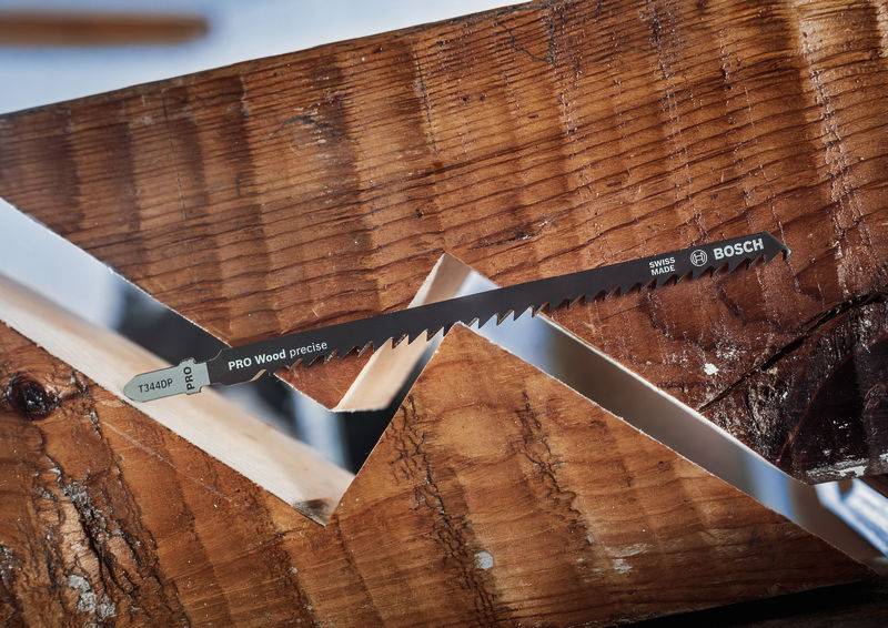 Žagino rezilo za les z napisom 'PRO Wood precision' podjetja Bosch, vpeto v leseno podlago, prikazuje natančnost reza.